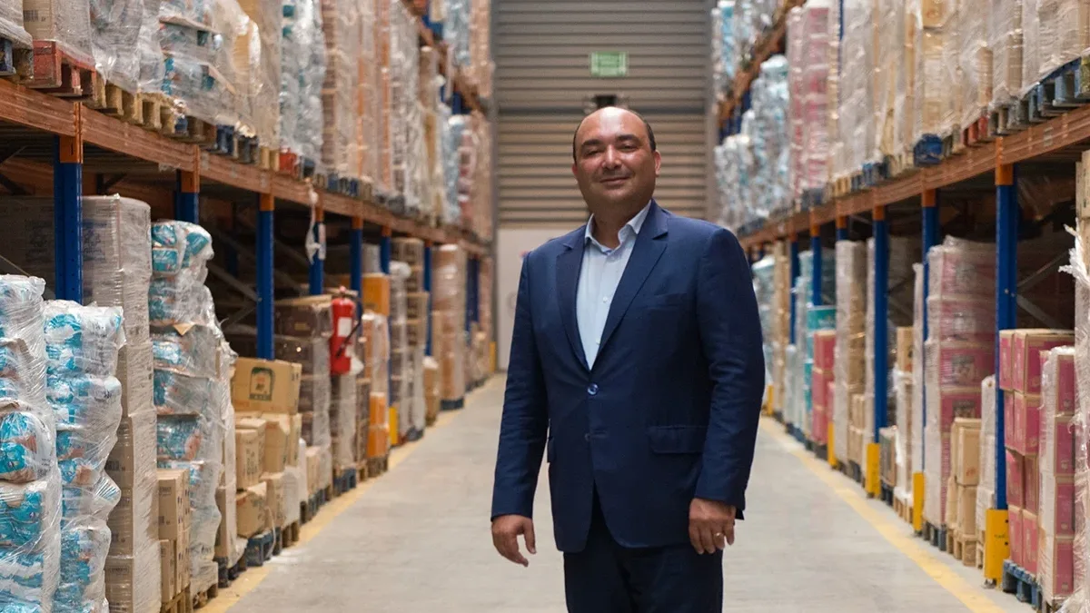 Dislog et l’équation MCDF : l’art de l’intégration industrielle par le haut Moncef Belkhayat, PDG de Dislog Group, posant en costume dans une allée d'entrepôt logistique | L'Essentiel.ma